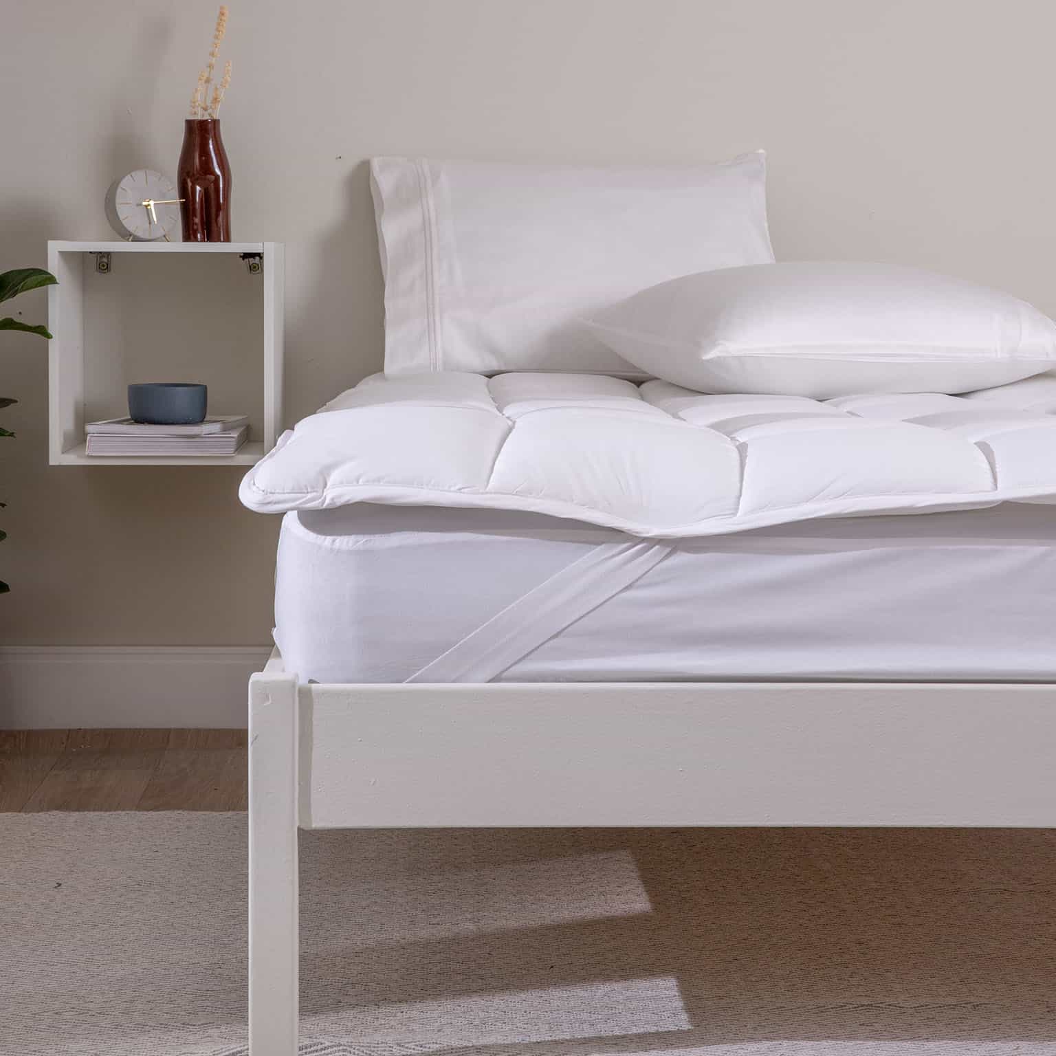 cama com colchão, pillow top e travesseiros brancos 
